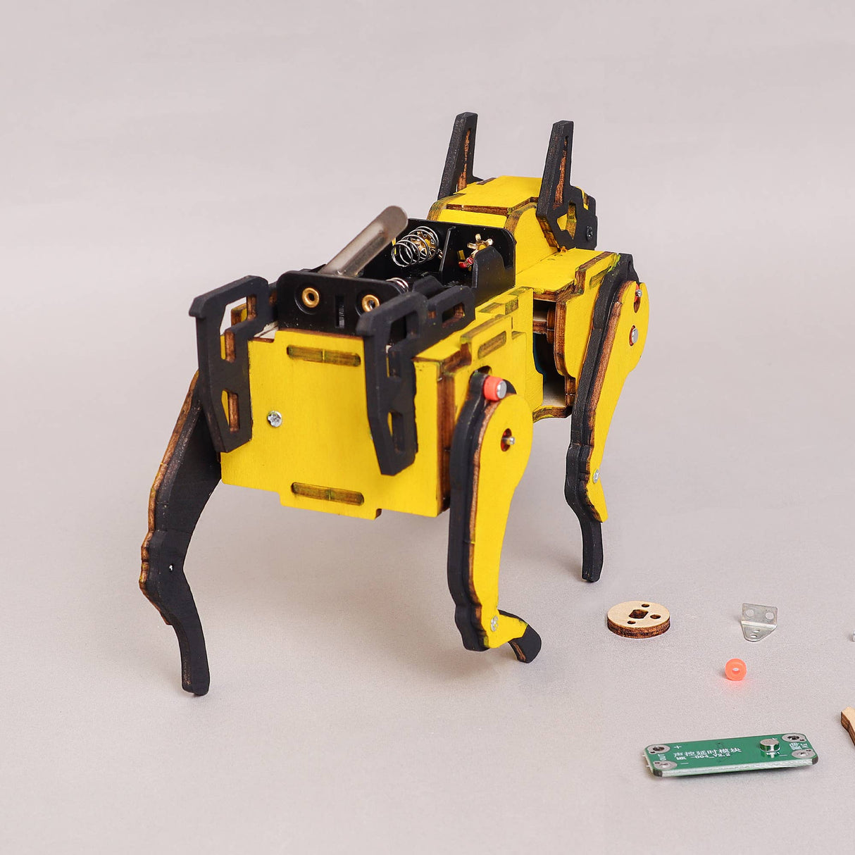 Yellow and black robot dog model on a light gray background