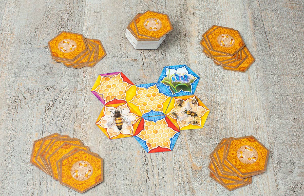 Hexagonal tiles with bee designs on a wooden surface