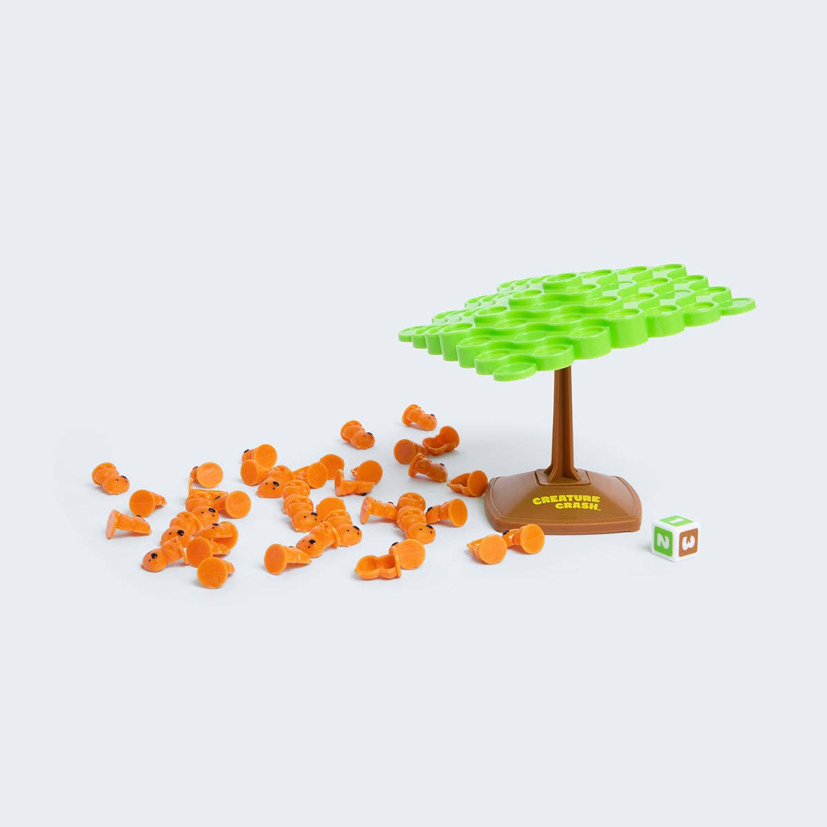 Board game components including orange tokens, a green tree-like structure, and a brown base on a white background.
