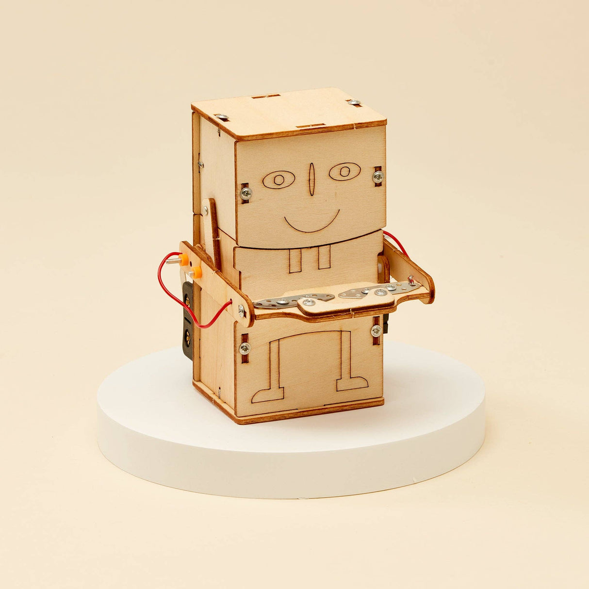 Wooden robot model on a white pedestal with a beige background