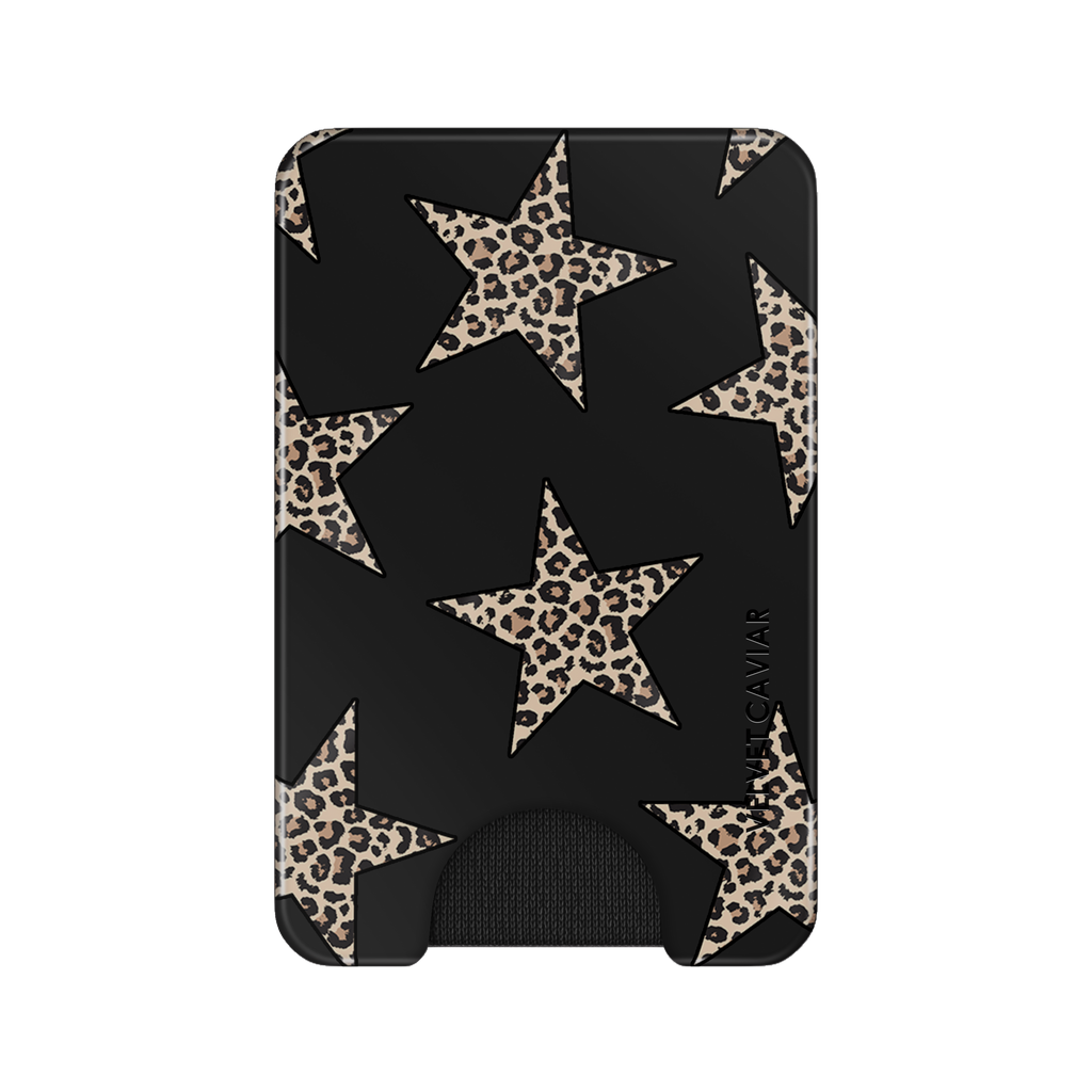 A slim black card holder wallet featuring a pattern of large beige and brown leopard-print stars, with a small black grip at the bottom and the brand name 'VELVET CAVIAR' printed vertically on the right side.