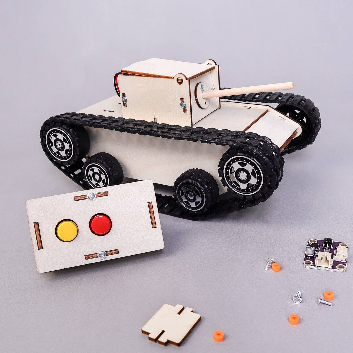 Wooden tank model kit with control panel and components on a gray background