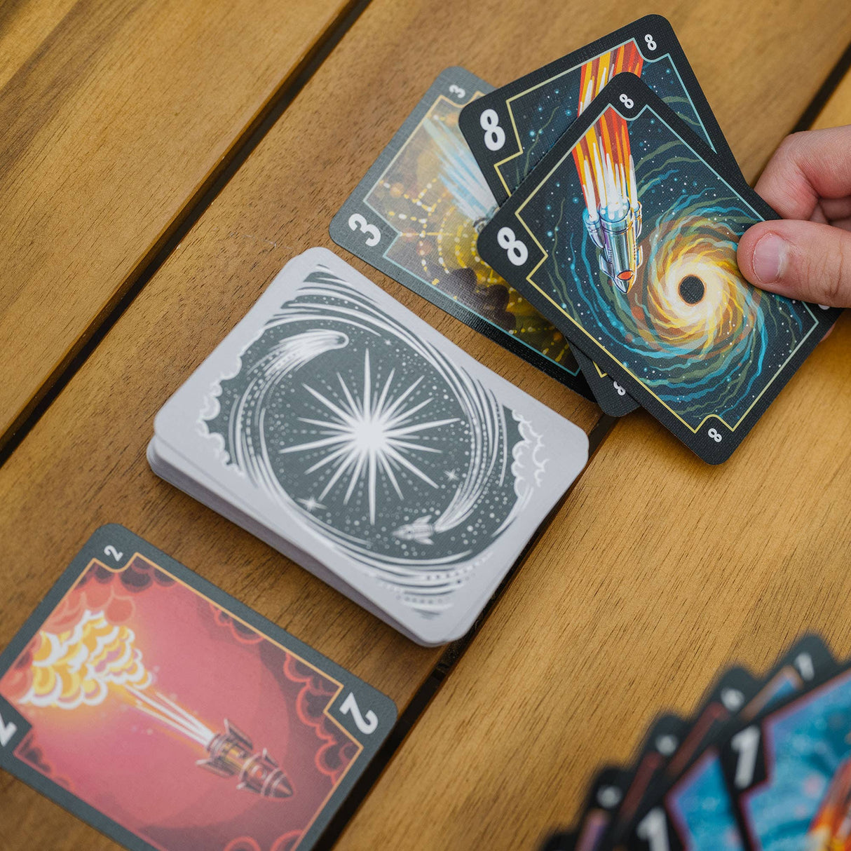 Playing cards with unique designs on a wooden surface