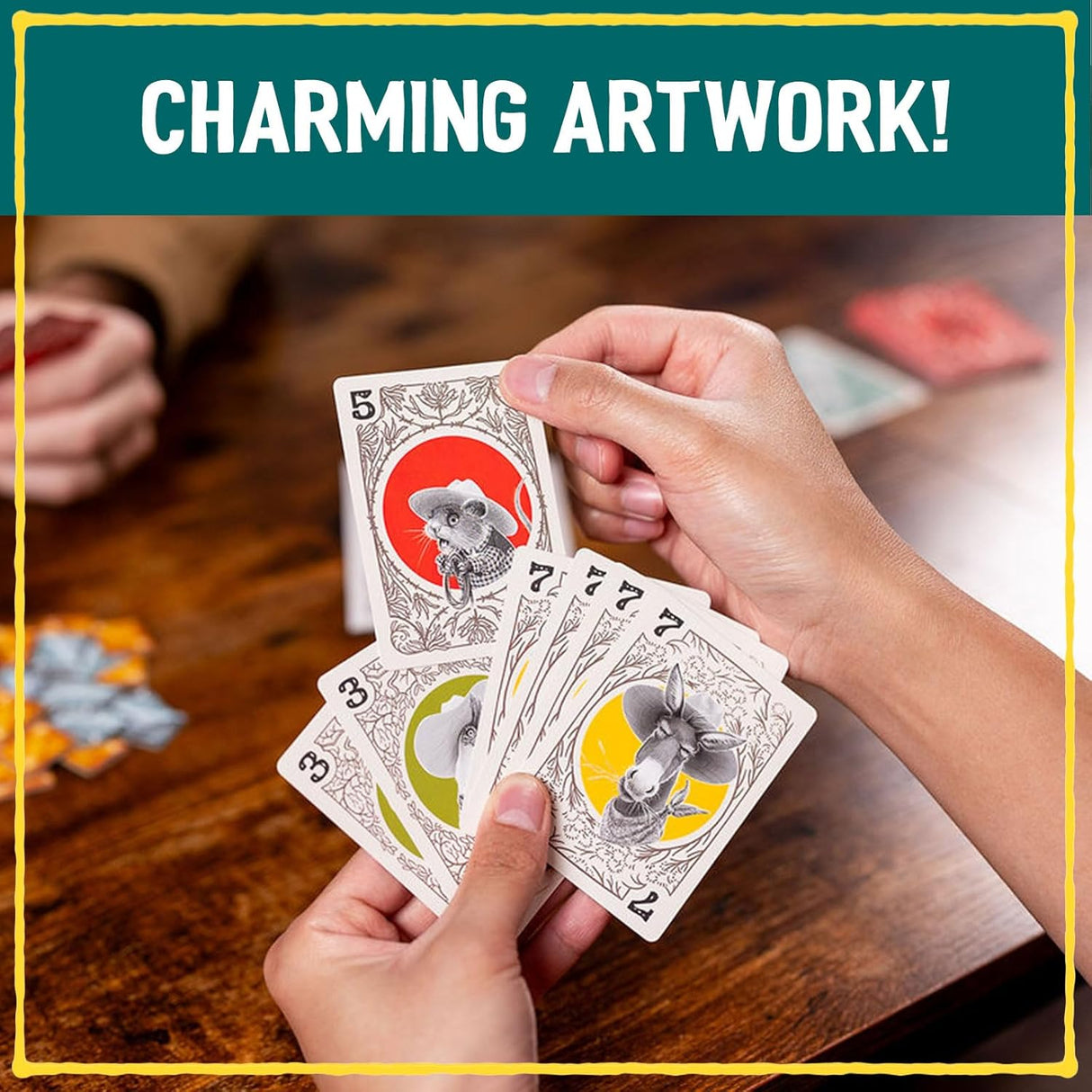 Hands holding playing cards with animal illustrations on a wooden table, text 'Charming Artwork!' at the top.