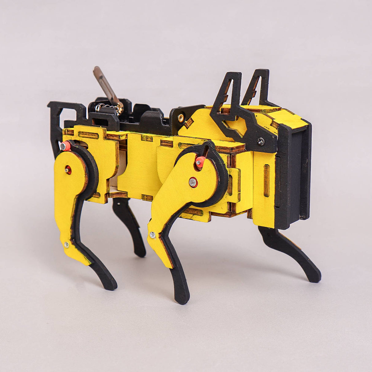 Yellow and black mechanical model on a light gray background