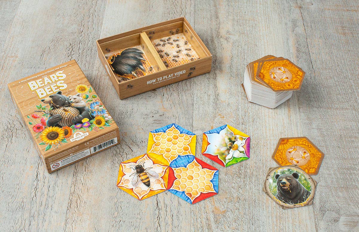 Board game components including hexagonal tiles and a box on a wooden surface