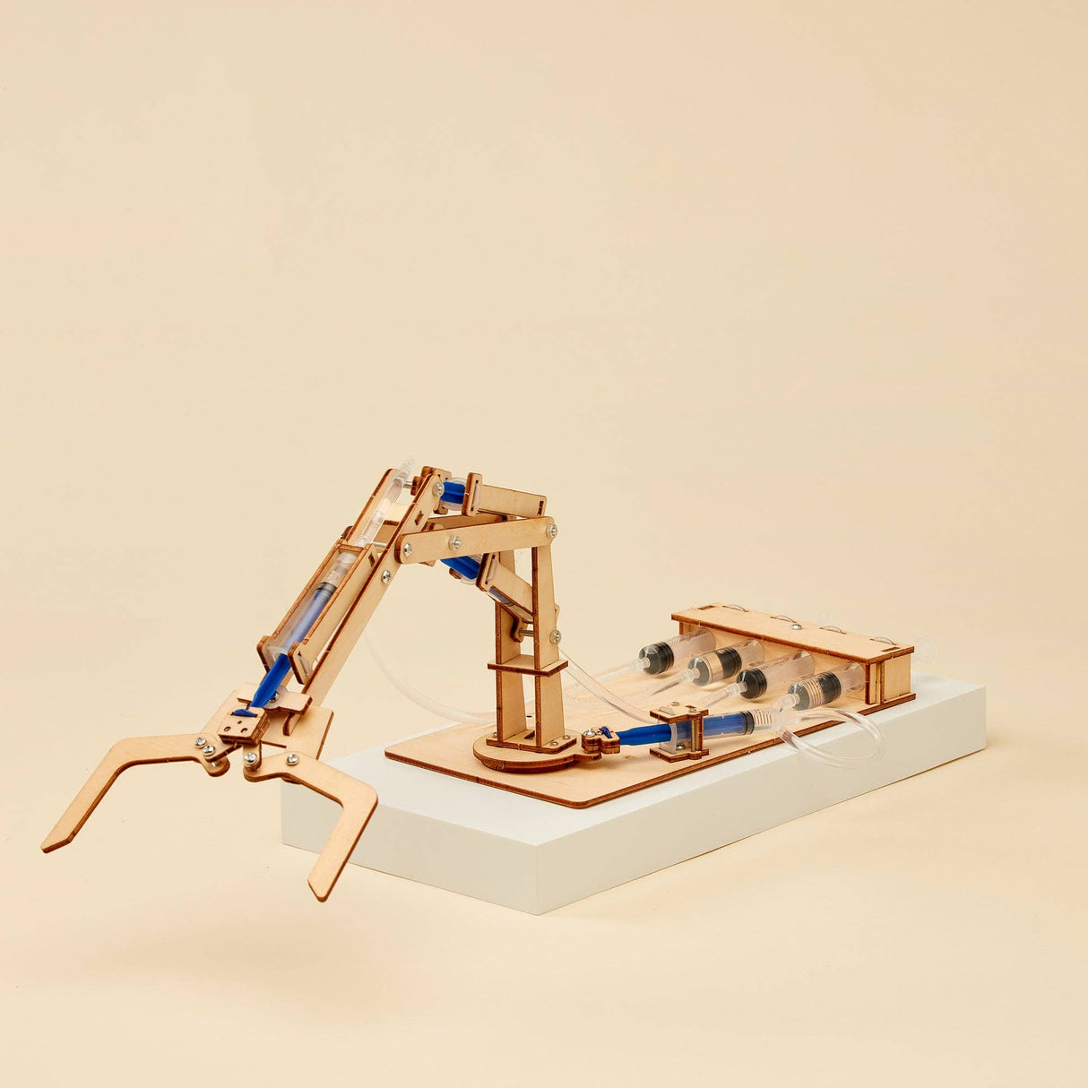 Wooden mechanical arm model on a beige background