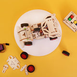 Wooden robot model on a white plate with remote control and parts on a yellow background