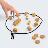 Wooden geometric shapes on a black drawstring bag with a hand reaching towards them.