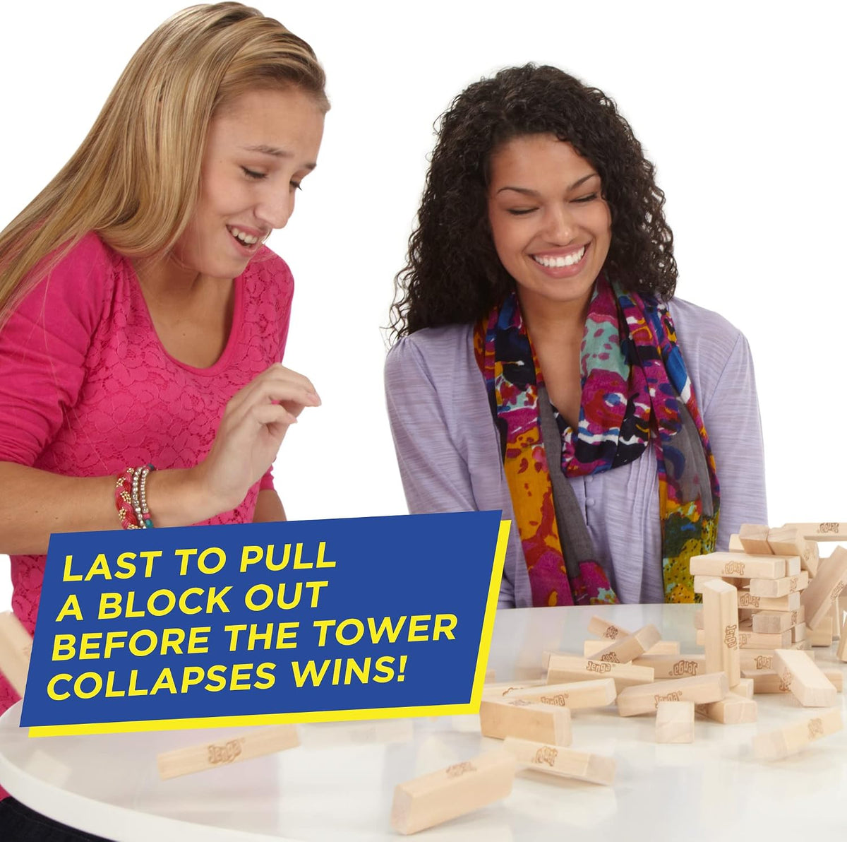 Players pulling the last block before the Jenga tower collapses