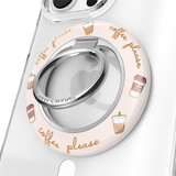 A clear phone case with a circular light pink protective bumper featuring 'coffee please' script and iced coffee illustrations. The bumper includes a silver metallic ring stand in the center.