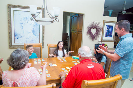 Family playing SKYJO at a dining table