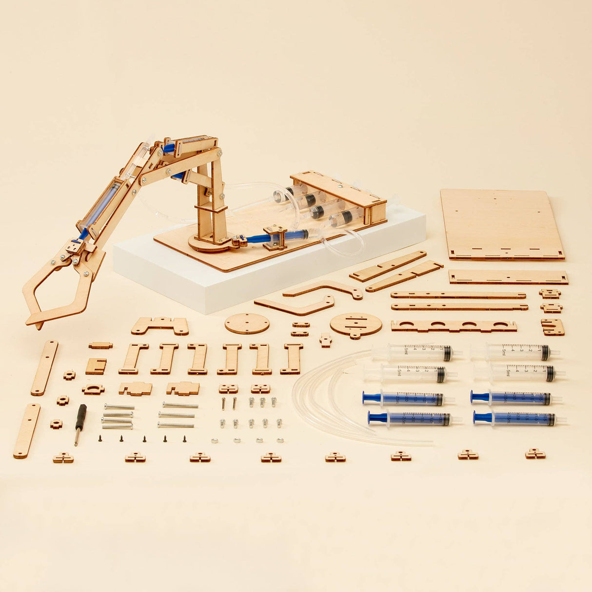 Wooden mechanical model kit with components on a beige background