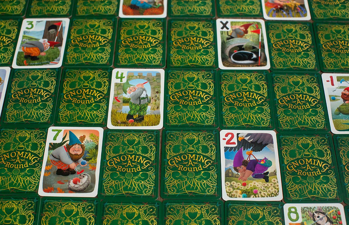 Collection of 'Gnoming Around' card game cards on a green patterned surface.