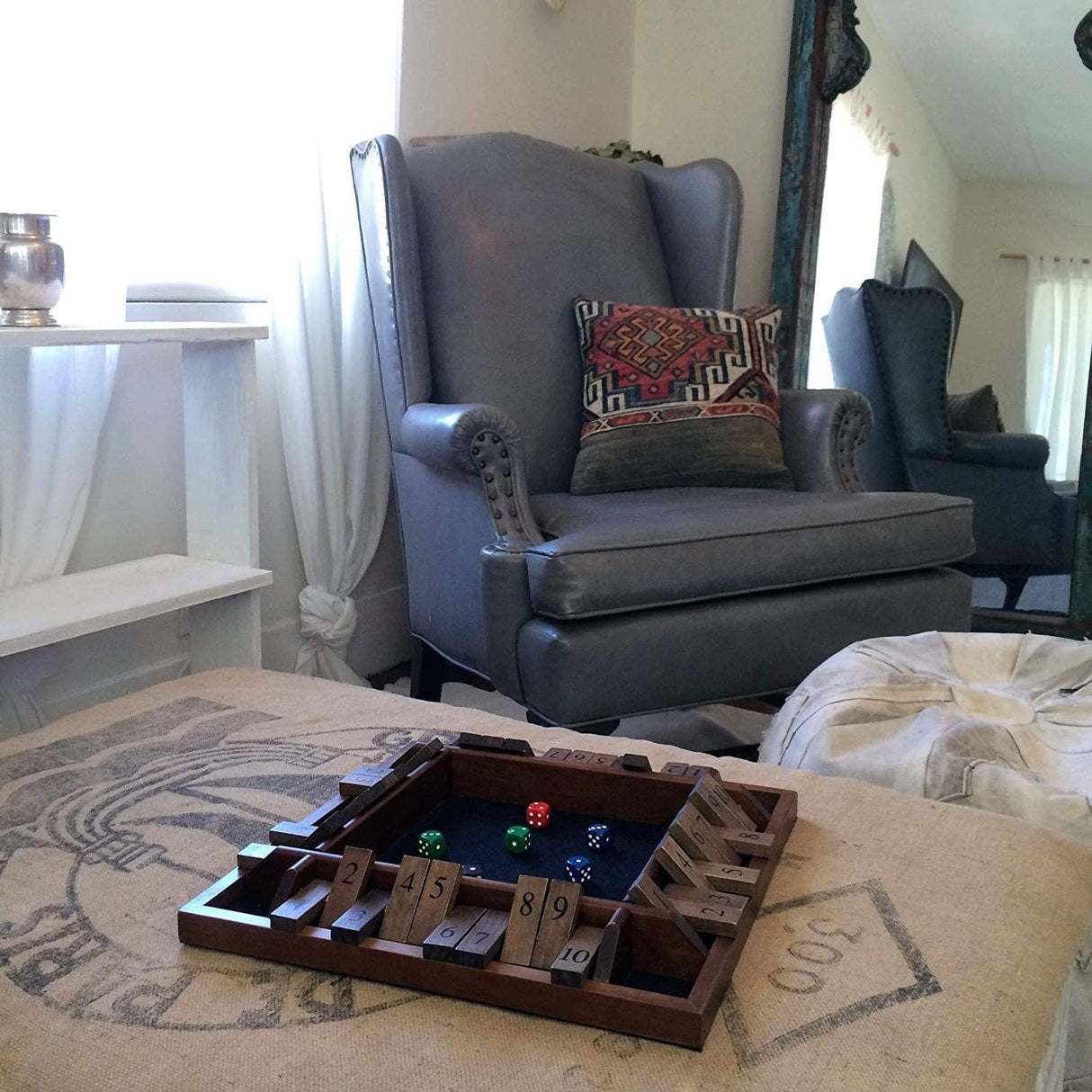 Wooden dice tray with dice on a coffee table in a living room.