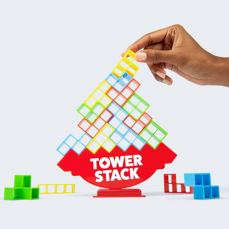 Colorful tower stack game with a hand placing a block on top, on a white background.