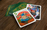 Colorful playing cards with gnome illustrations on a wooden surface