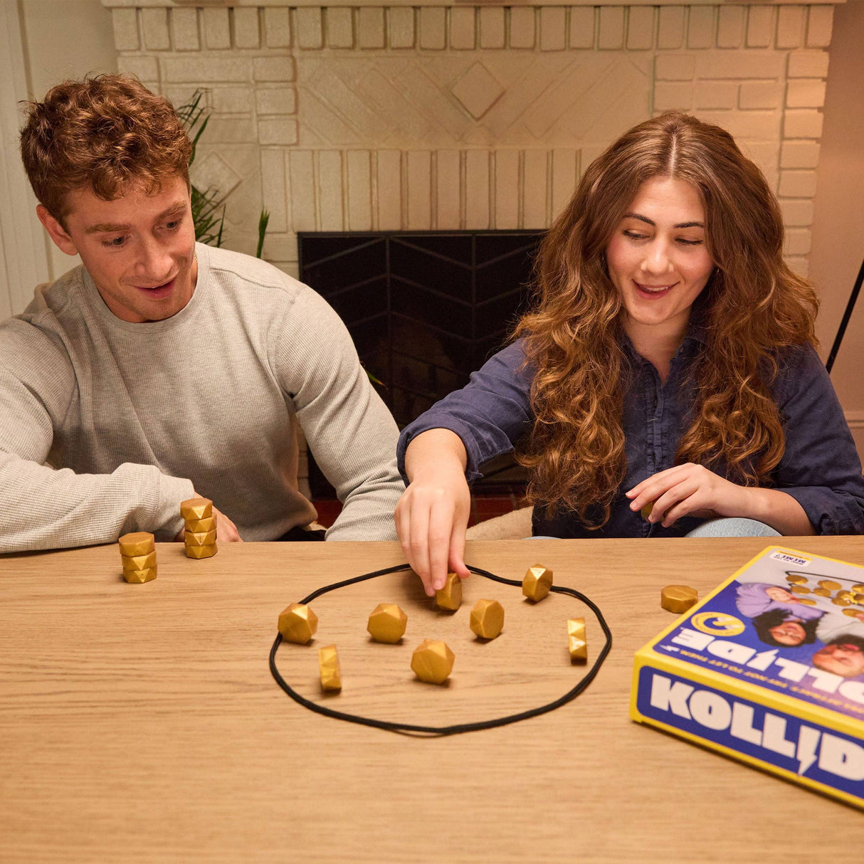 Two people playing a board game with game pieces on a wooden table.