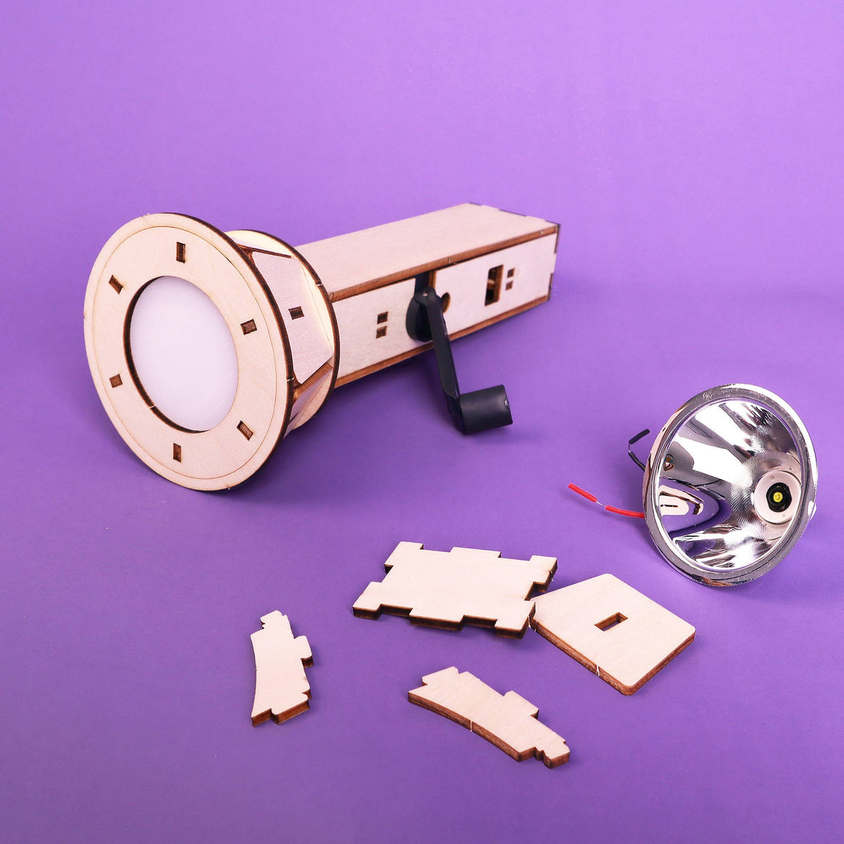 Wooden laser-cut components of a lamp on a purple background