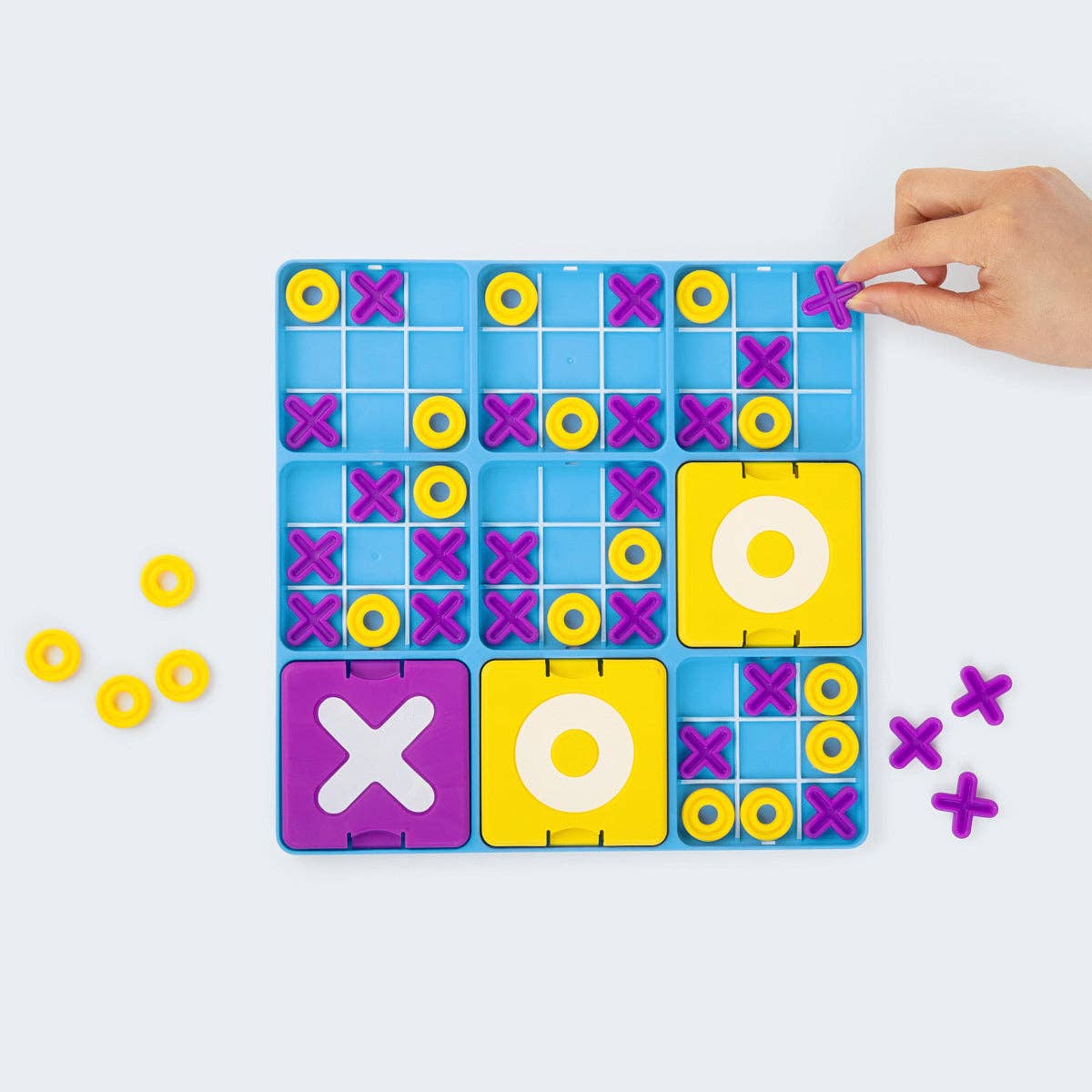 Colorful tic-tac-toe game board with pieces on a white background