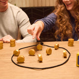 Two people playing a game with geometric wooden pieces on a table.