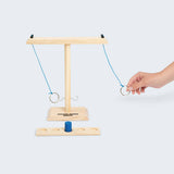 Wooden ring game with a hand interacting with it on a white background